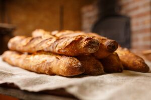 A photo of half a dozen baguettes on a table.