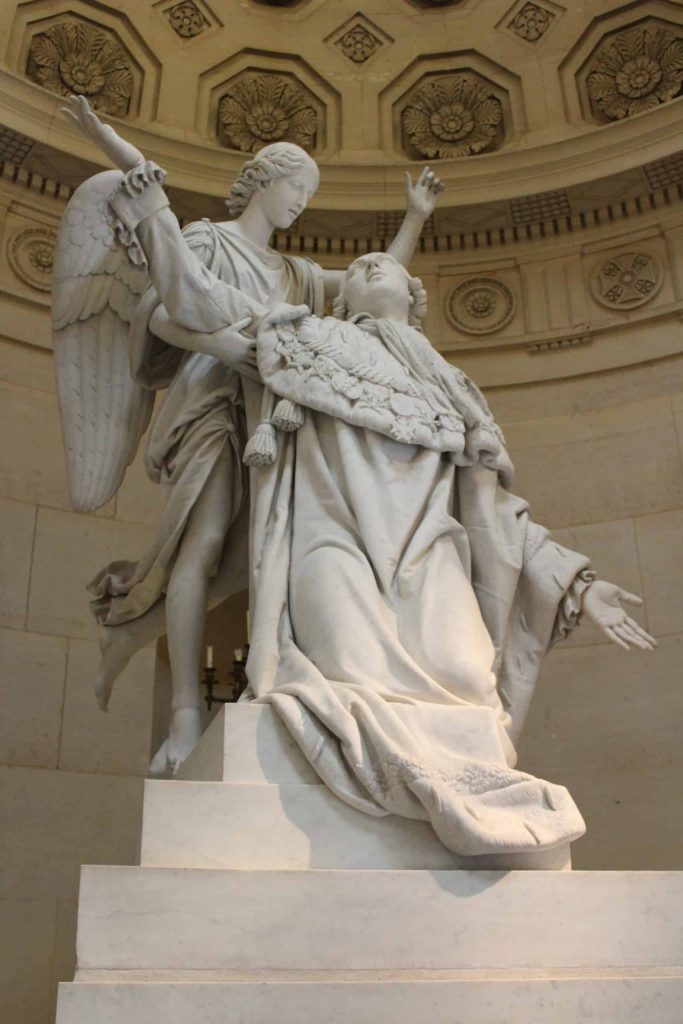 A photo of a statue of Louis XVI being supported by an angel in the Chapelle Expiatoire.