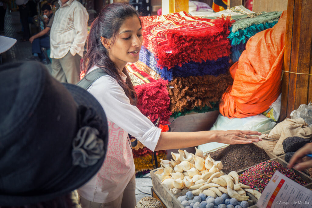 A photo of a food tour guide explaining spice in a Dubai souk for a group tour.